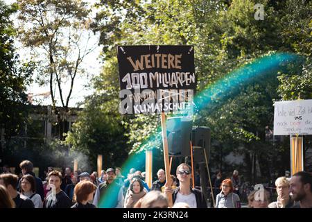 Teilnehmer*in mit Schild 'Weitere 100 Milliarden für den Krieg (durchgestrichen) Klimaschutz'. AM 23.9.2022 versammelten sich in München bis zu 10,000 Menschen, UM gemeinsam mit Fridays for future auf dem Globalen Klimastreik für Klimagerechtigkeit, den Ausbau der dezentralen erneuerbaren Energien, kostengünstigen ÖPNV und für ein 100 MRD. Euro Sondervermögen für gerechte Klimaschutzmaßnahmen und Krisenprävention zu demonstrieren. DAS devise des Großstreiks guerre wieder personnes à but non lucratif. -- participant avec le signe '100 milliards de plus pour la guerre (barré) la protection du climat". Septembre Banque D'Images