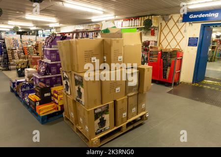 Une palette de boîtes brunes sur un magasin avec des articles en attente d'être placés sur des tablettes pour le stockage Banque D'Images
