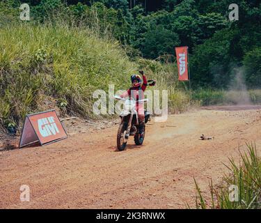 Pahang, Malaisie - 24 septembre 2022 une motard féminine se réjouit après avoir terminé à l'événement Rimba RAID. Banque D'Images