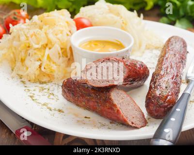 saucisses de viande savoureuses avec sauce moutarde et chou Banque D'Images