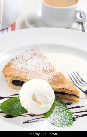 Savoureux gâteau aux graines de pavot avec glace sur une assiette blanche avec une tasse d'Americano Banque D'Images