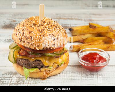 Hamburger savoureux avec bœuf, bacon, fromage, concombre, tomate Banque D'Images