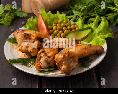 ailes de poulet grillées décorées de légumes Banque D'Images