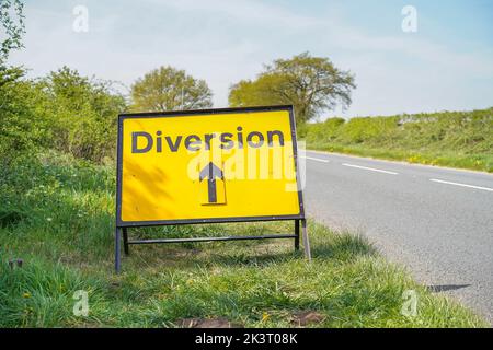 Panneau de signalisation jaune « version » en position, isolé par le côté d'une route de campagne britannique sans circulation. Banque D'Images