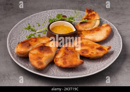 posikunchiki - petites tartes avec sauce à la viande et à la moutarde Banque D'Images