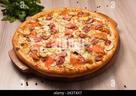 pizza savoureuse avec saucisses, concombres, tomates et champignons Banque D'Images