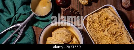 Glace épicée d'automne au goût de châtaignes grillées, aux épices, sur un fond de bois avec des châtaignes fraîches et grillées Banque D'Images