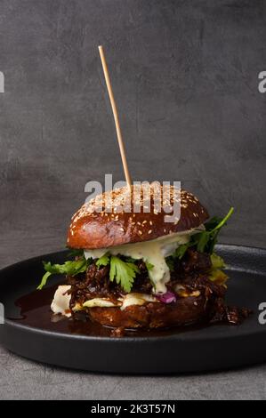 grand hamburger au veau bouilli, sauce worcestershire, fromage brie. cadre vertical Banque D'Images