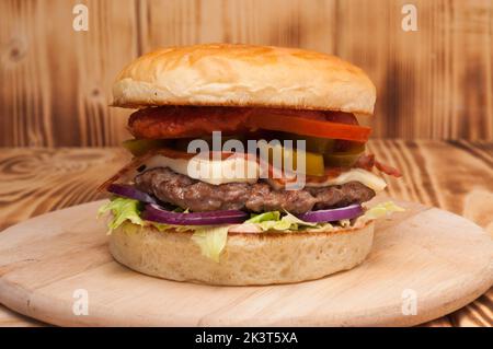 hamburger savoureux avec patty de bœuf, bacon, jalapeno, fromage, tomate et oignon Banque D'Images