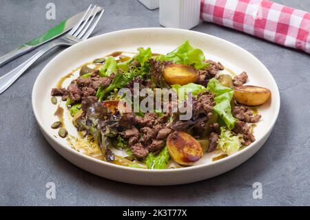 salade chaude savoureuse avec pommes de terre, foie et concombre mariné Banque D'Images