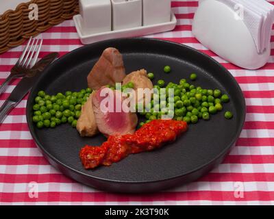 savoureux thon avec purée de pommes de terre et petits pois verts au restaurant Banque D'Images