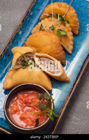 POSIKUNCHIKI - petites tartes savoureuses avec garniture de viande, sauce tomate. Gros plan. Banque D'Images