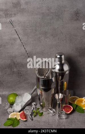 ensemble d'outils de barman décorés de fruits sur fond gris Banque D'Images