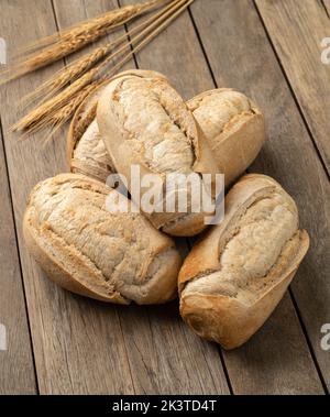 Pain français à grains entiers, pain salé ou pistolet sur table en bois. Banque D'Images