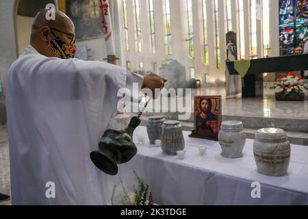 Manille, Philippines. 28th septembre 2022. Prêtre catholique FR. Flaviano ''Flavie'' Villanueva diffuse de l'encens sur les urnes des victimes de la guerre contre la drogue lors d'un service commémoratif à l'intérieur d'une église catholique de la ville de Quezon, dans la région métropolitaine de Manille, aux Philippines. 28 septembre 2022. Les restes ont été exhumés de leurs tombes après que le bail sur les tombes dans un cimetière public qu'ils ont été enterrés a expiré et les parents ne pouvaient pas se permettre de continuer avec elle. (Image de crédit : © Basilio Sepe/ZUMA Press Wire) Banque D'Images