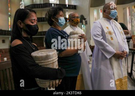 Manille, Philippines. 28th septembre 2022. Les membres de la famille et les parents reçoivent les urnes qui tiennent les cendres des victimes de la guerre contre la drogue lors d'un service commémoratif à l'intérieur d'une église catholique de la ville de Quezon, dans la région métropolitaine de Manille, aux Philippines. 28 septembre 2022. Les restes ont été exhumés de leurs tombes après que le bail sur les tombes dans un cimetière public qu'ils ont été enterrés a expiré et les parents ne pouvaient pas se permettre de continuer avec elle. (Image de crédit : © Basilio Sepe/ZUMA Press Wire) Banque D'Images