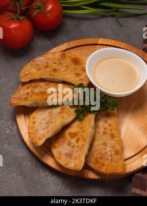 petits tourtes posikunchiki avec sauce moutarde sur une planche de bois Banque D'Images