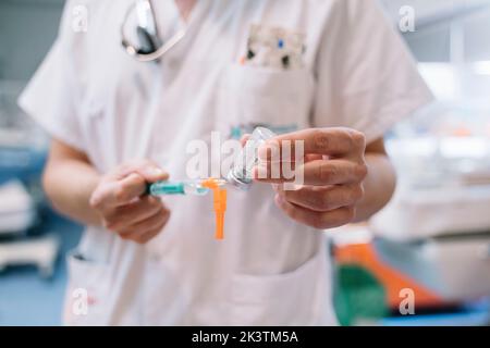 Mains à focale molle médecin méconnaissable remplissant la seringue avec une solution de l'ampoule pour injection en clinique Banque D'Images