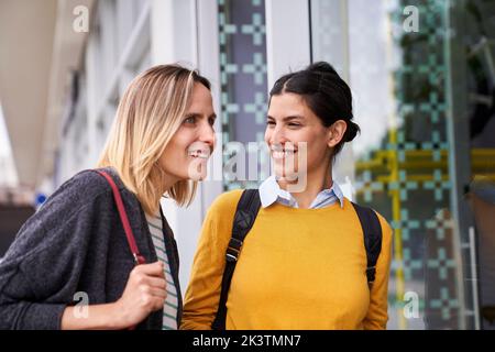 Photo de deux amies qui se promette à l'extérieur tout en faisant du shopping dans la fenêtre Banque D'Images
