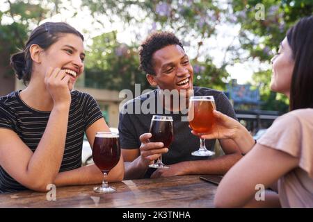 Divers groupes d'amis heureux qui pendent de la bière artisanale à l'happy hour Banque D'Images