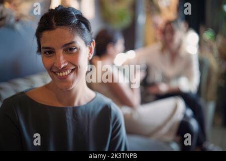 Portrait d'une femme latino-américaine attrayante regardant l'appareil photo avec ses amies en arrière-plan Banque D'Images
