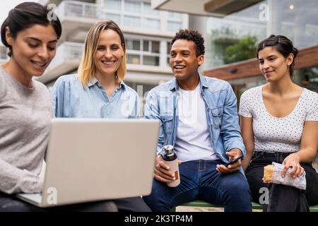 Divers groupes de collègues discutent de questions de travail en travaillant à l'extérieur Banque D'Images