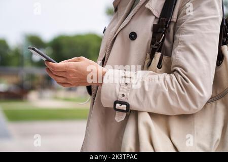 Prise de vue moyenne des mains d'une femme tenant un téléphone cellulaire Banque D'Images