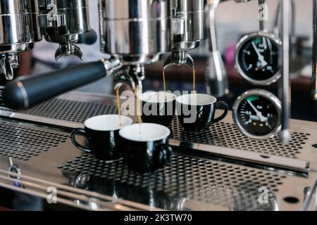 Du café fraîchement aromatique dans le compartiment de la machine à café avec tasses à café Banque D'Images