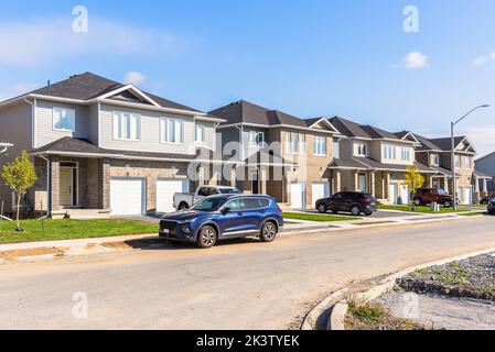 Nouvelles maisons mitoyennes le long d'une rue dans un développement de logements le jour d'automne ensoleillé Banque D'Images