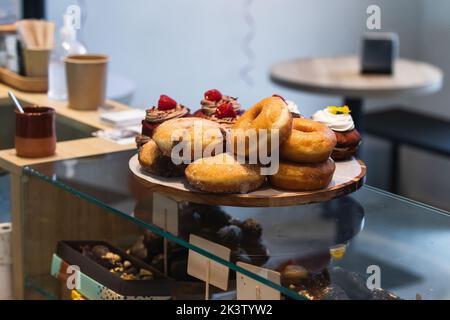 Divers beignets et gâteaux vegan sur plateau en bois placé sur le comptoir de la boulangerie Banque D'Images