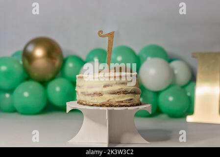 Délicieux gâteau d'anniversaire maison pour célébrer un an sur le stand près des ballons pour la fête Banque D'Images