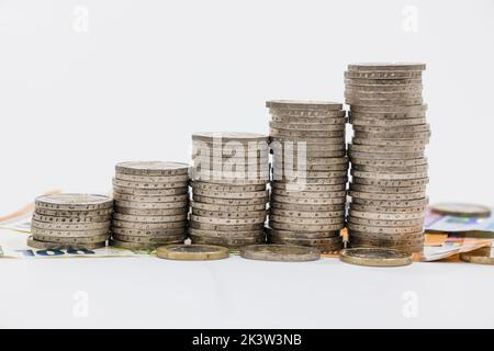 Pile de pièces en euros ascendantes sur fond de billet de banque. Finance, banque et épargne Banque D'Images