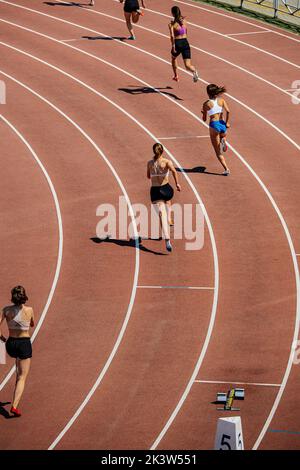 les athlètes féminins de groupe commencent à courir 400 mètres Banque D'Images