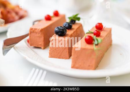 Buffet de banquet. Salade de grenade aux profiteroles farcies et tartelettes dans une assiette isolée sur fond blanc. En-cas pour les fêtes. Banque D'Images