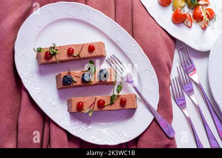 Buffet de banquet. Salade de grenade aux profiteroles farcies et tartelettes dans une assiette isolée sur fond blanc. En-cas pour les fêtes. Banque D'Images