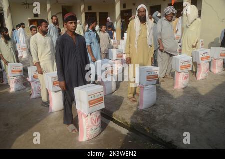 Peshawar, Pakistan. 22nd septembre 2022. Les personnes touchées par les inondations reçoivent une aide de secours distribuée par la Fondation Al Khidmat dans le district de Nowshera, dans le village de Garhi Momin, dans la province de Khyber Pakhtunkhwa à Peshawar, au Pakistan, le 22 septembre 2022. (Photo de Hussain Ali/Pacific Press/Sipa USA) crédit: SIPA USA/Alay Live News Banque D'Images