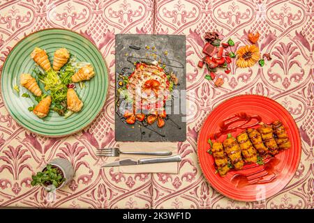 Plusieurs assiettes de nourriture avec croquettes, cônes avec salade et salade russe avec tomate et thon en conserve Banque D'Images