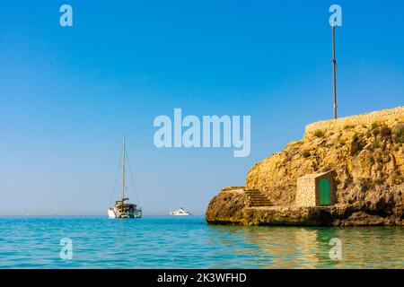 Palma, Majorque, Espagne. Un voilier amarré à la plage de Cala Major, à côté de l'île es Pujolar Banque D'Images