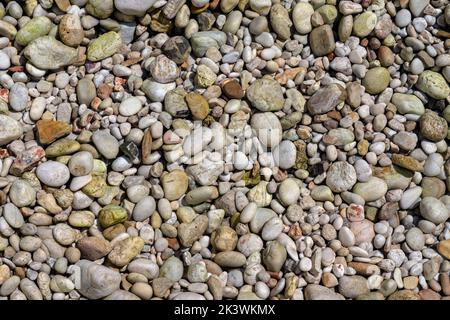 Le soleil brille à de petites pierres de gravier à la plage de Limni à Corfou, en Grèce - la mer est claire ici - les rochers dans la photo sont en fait sous l'eau peu profonde Banque D'Images