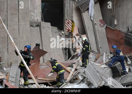 Les sauveteurs travaillent sur un site d'une école secondaire qui a été lourdement endommagé par les bombardements russes à Mykolaivka. Dmitry Peskov, attaché de presse du président russe, a déclaré que la Russie poursuivra la guerre même après des référendums fictives, et qu'elle visera à occuper tout le territoire de l'oblast de Donetsk. Banque D'Images