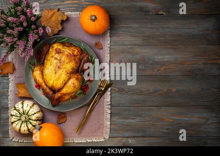 Thanksgiving. Poulet rôti ou dinde pour un dîner festif sur une table en bois. Concept de Thanksgiving. Copier l'espace Banque D'Images