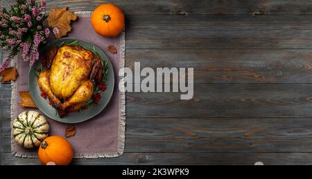 Thanksgiving. Poulet rôti ou dinde pour un dîner festif sur une table en bois. Concept de Thanksgiving. Copier l'espace Banque D'Images