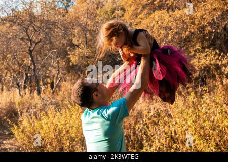 papa et fille dansent dans la nature.une petite ballerine danse avec son père. petite princesse.papa tient sa fille dans ses bras. soutien de danse Banque D'Images