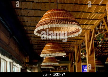 Lampes en osier, toit en bois. Décoration intérieure tendance d'un café hippster dans un style loft. Banque D'Images