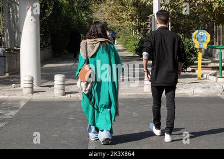 Téhéran, Téhéran, Iran. 28th septembre 2022. Un couple iranien marche dans une rue, à Téhéran, Iran, le 28 septembre 2022. L'Iran a été confronté à de nombreuses manifestations anti-gouvernementales à la suite de la mort de Masha Amini, une jeune fille de 22 ans, qui a été détenue le 13 septembre par l'unité de police chargée d'appliquer le strict code vestimentaire pour les femmes en Iran. Amini a été déclarée morte le 16 septembre, après avoir passé 3 jours dans le coma. Des manifestations ont commencé à Saqez, la ville natale d'Amini, lors de ses funérailles le 17 septembre. (Credit image: © Rouzbeh Fouladi via ZUMA Press Wire) Banque D'Images