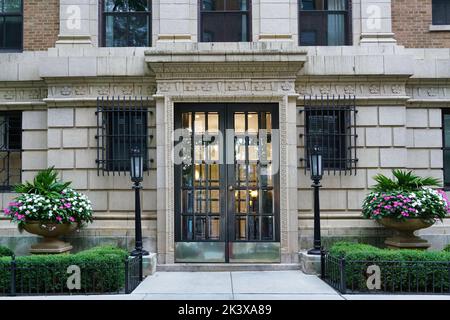 Porte d'entrée de l'élégant immeuble d'appartements avec de grands pots de fleurs Banque D'Images