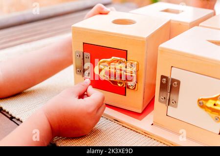 Boîtes en bois avec serrures, matériel éducatif montessori pour manipuler des objets par des enfants avec dextérité. Banque D'Images