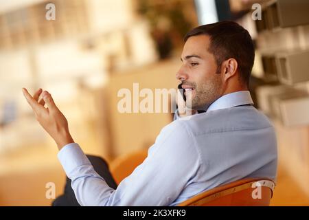 Permettez-moi d'expliquer les termes une fois de plus... Un beau jeune homme d'affaires qui utilise son smartphone. Banque D'Images