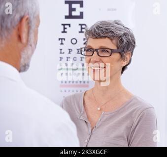 Pouvez-vous me voir maintenant. Une femme mûre portant des lunettes face à un optométriste. Banque D'Images