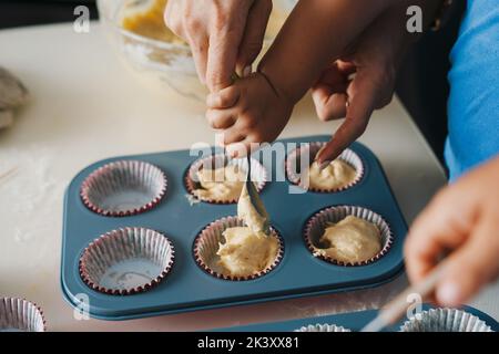 Cuisine familiale dans la cuisine verser de la pâte crue sous forme de silicone pour faire des gâteaux. Préparation de la cuisson. Gâteaux de Pâques. Traditions familiales et Banque D'Images